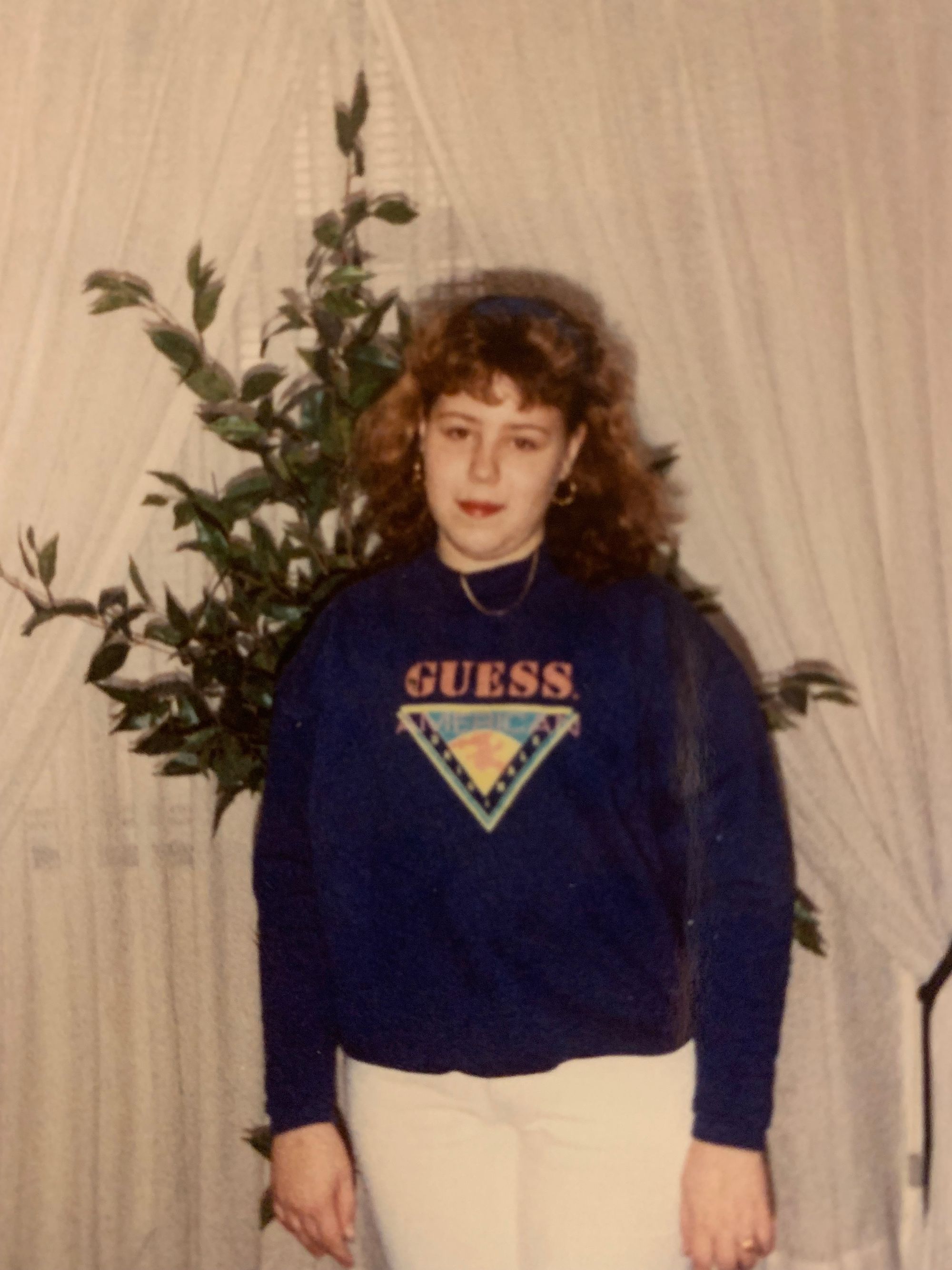 a chubby white 11 year old with unfortunate brown hair, wearing a blue Guess? sweatshirt and the obligatory guess jeans of the day. the person is smiling, but nevertheless looks resigned to whatever is going on.